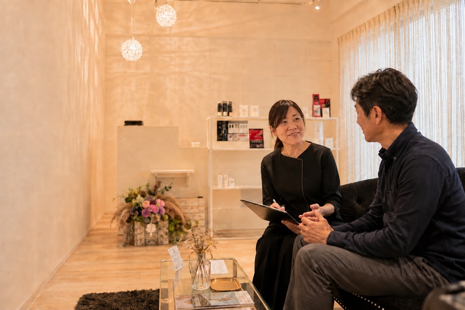 サロンでお客様の話を聞くオーナーセラピスト菅原直美